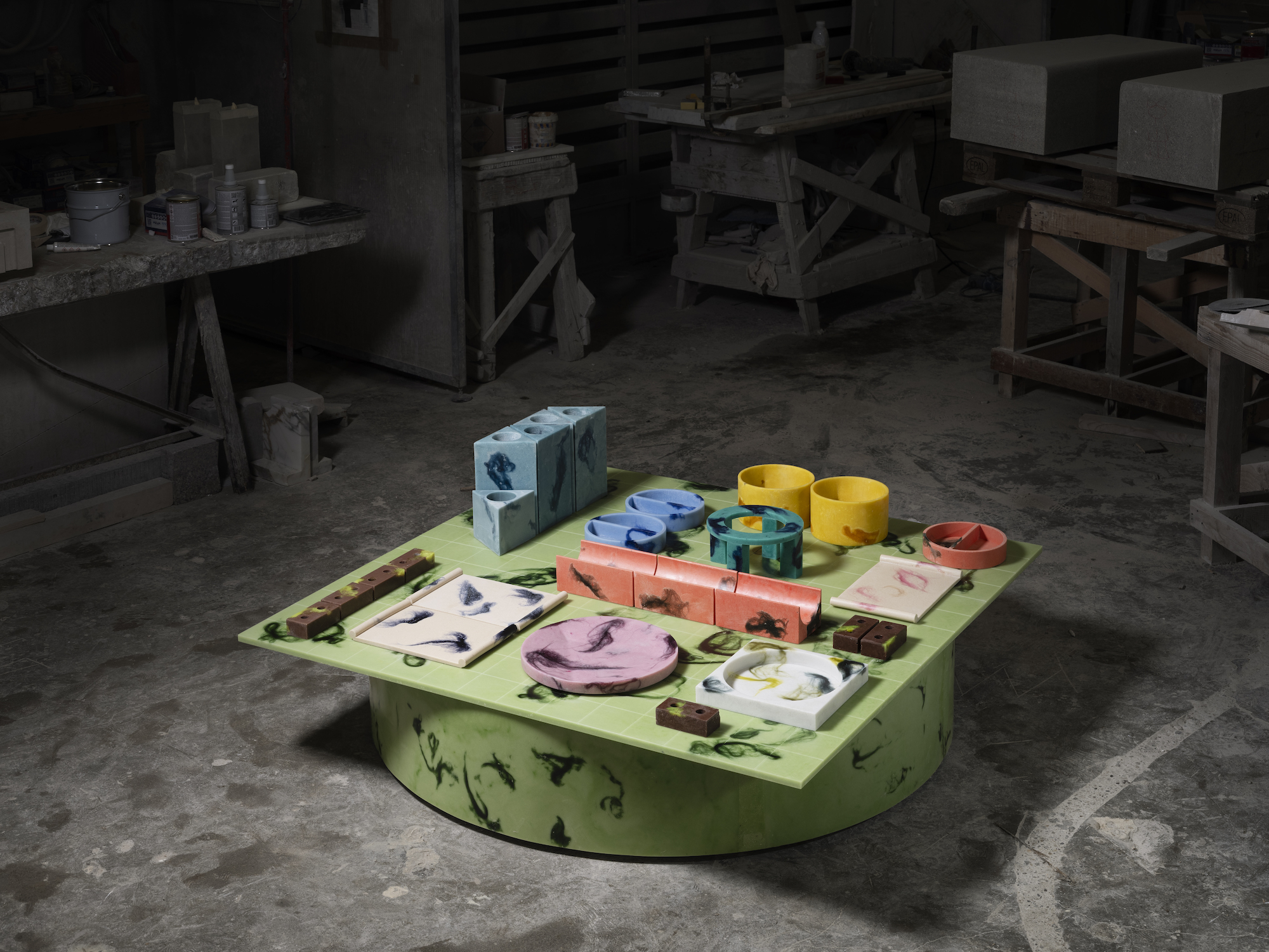 A small table structure in green with a variety of shapes, in different colours, arranged on top of the structure.