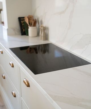 pale marble worktop which extends onto splashback