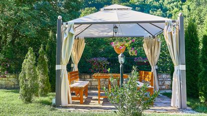 An example of the difference between a gazebo and a pergola, a gazebo decorated with lamps and hanging baskets