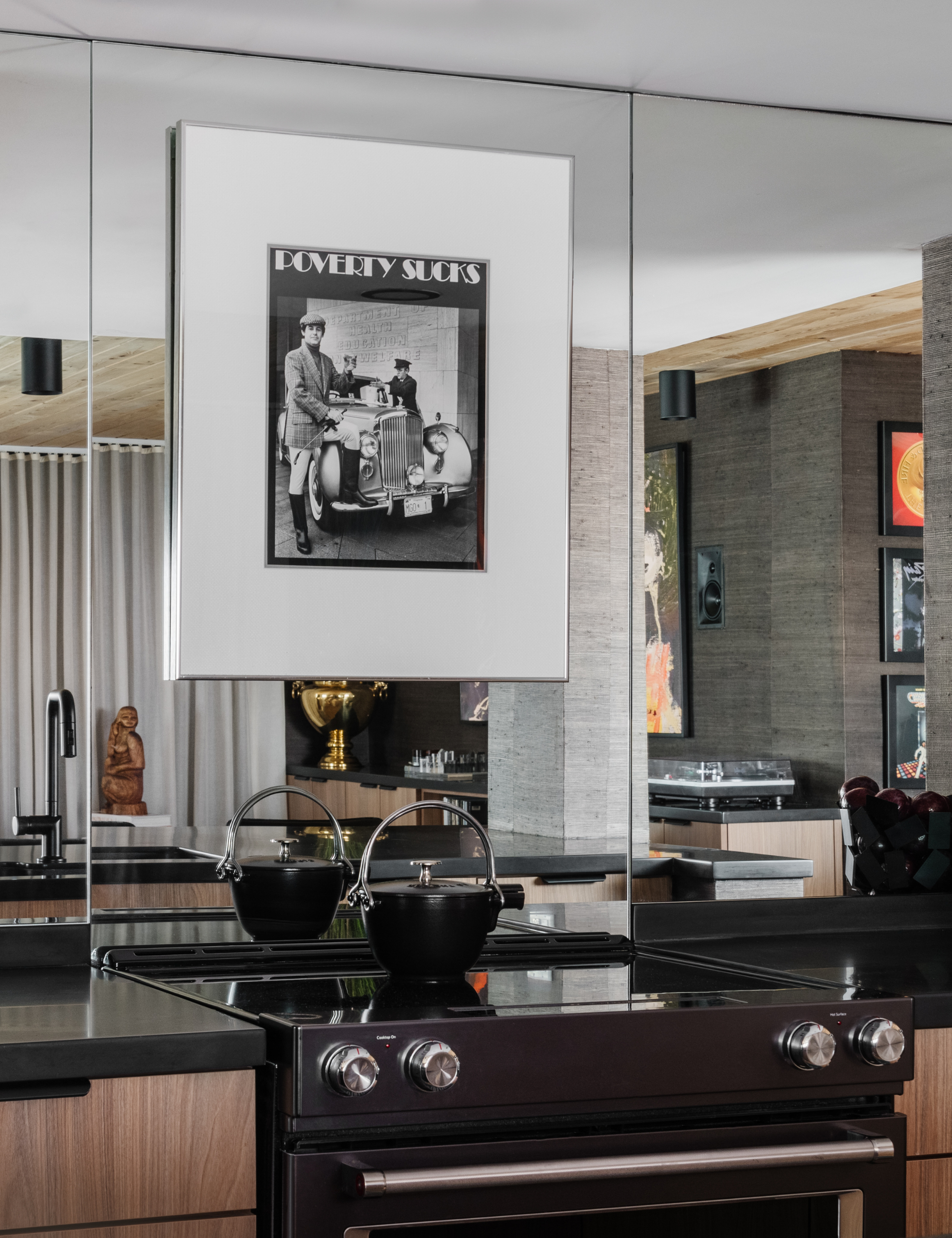 Modern kitchen featuring a mirrored backsplash and black-and-white artwork