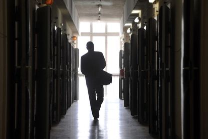A visitor walks down the hallway of a former prison in Berlin.