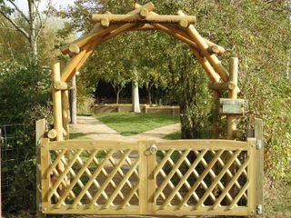 garden gate ideas: trellised fence beneath rustic archway from Jacksons Fencing