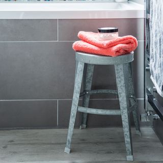 bathroom with tiled walls and steel stool