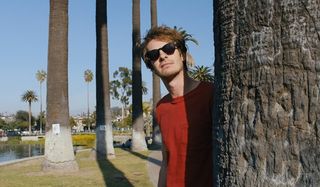 Under The Silver Lake Andrew Garfield wearing sunglasses in the park