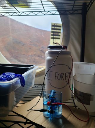 Officer Britaney Phillips's fuel cell experiment by the HI-SEAS habitat's window.