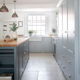 kitchen with white wall and grey counter with wooden top