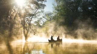 Two people canoeing in the mist in everglades national park