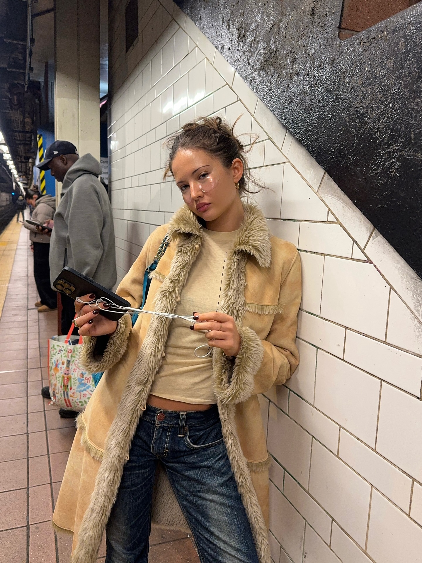 Girl posing for photo wearing shearling jacket and low-rise jeans