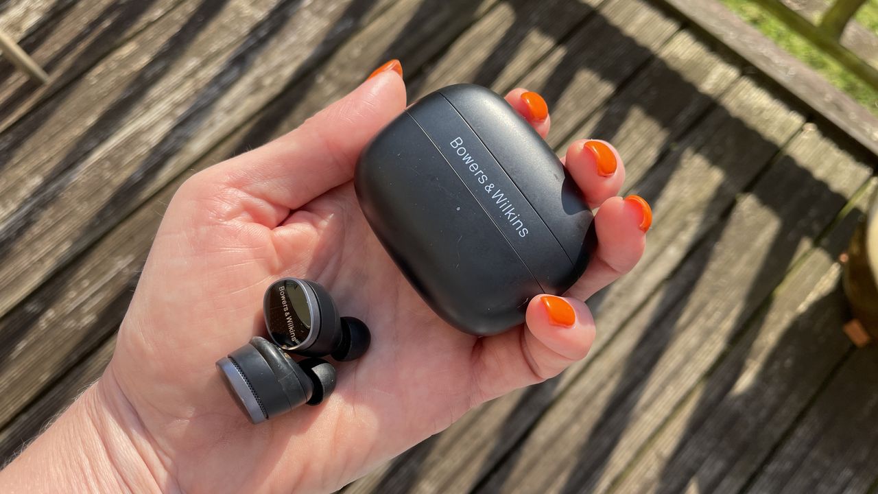 Bowers &amp; Wilkins Pi8 held in a hand, with floral background