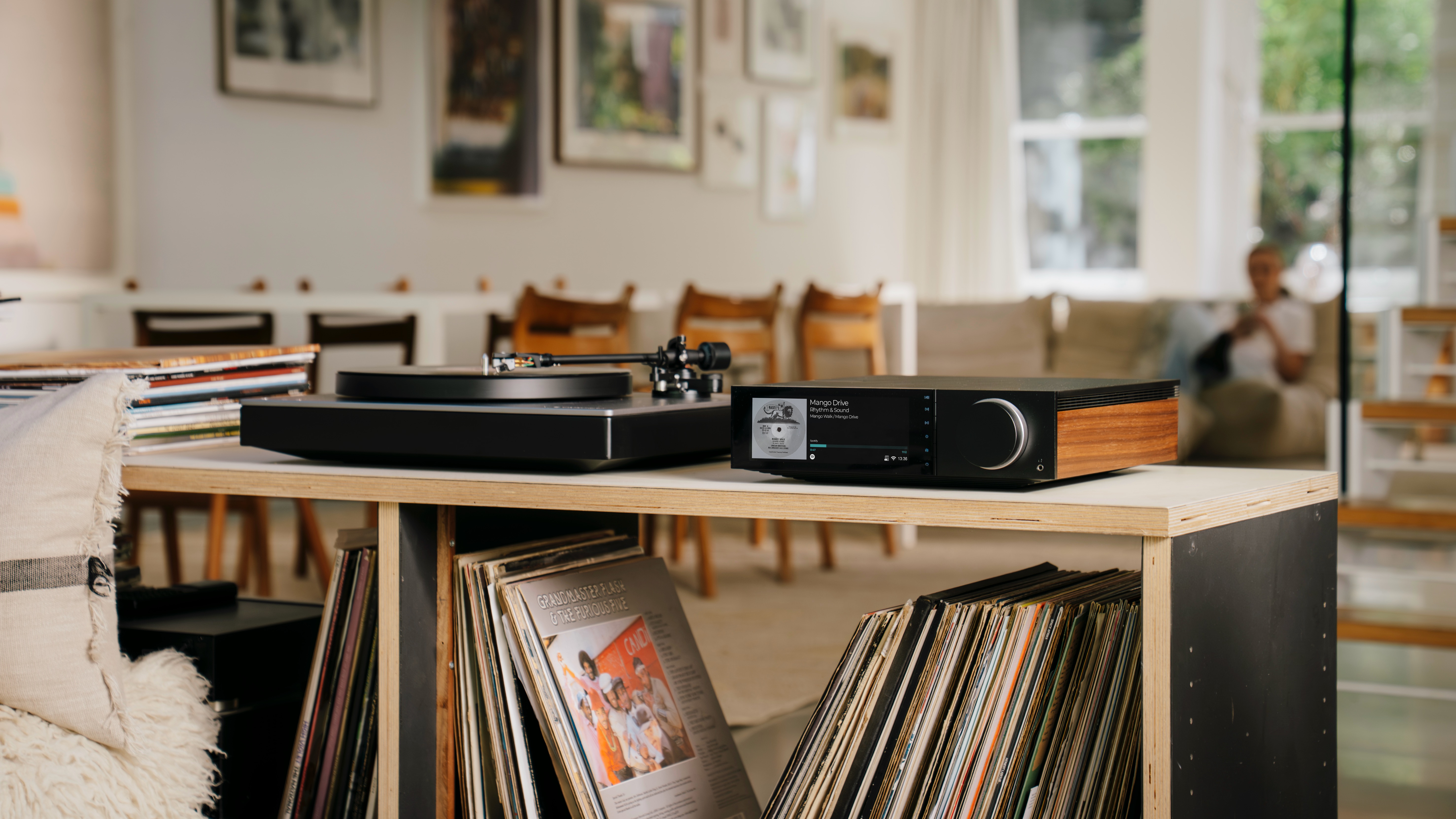 Cambridge Audio Evo 150 SE streaming amplifier in warm living room setting with vinyl records and books