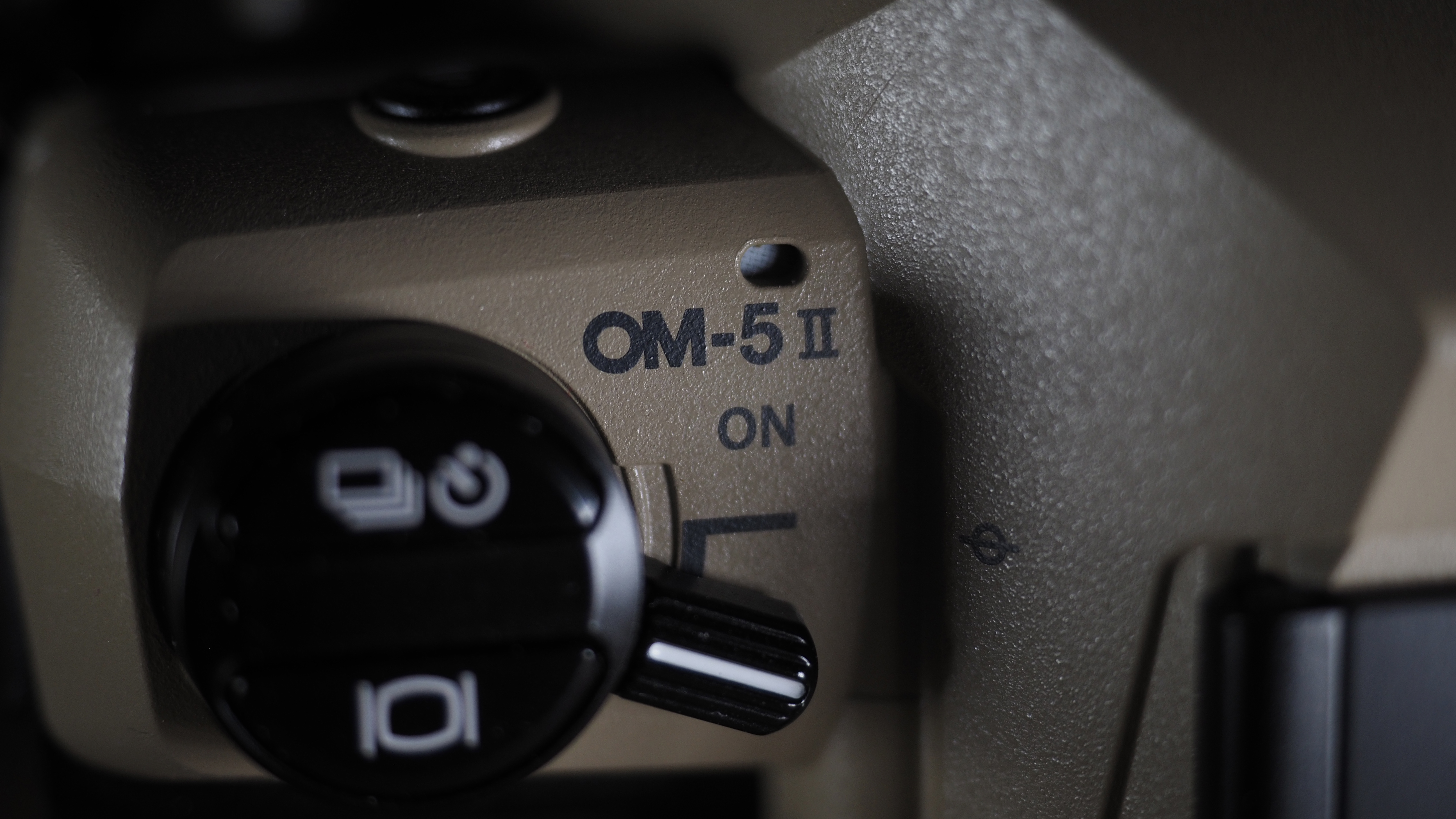 OM System OM-5 Mark II on a wooden surface with an Olympus M.Zuiko 12-45mm lens