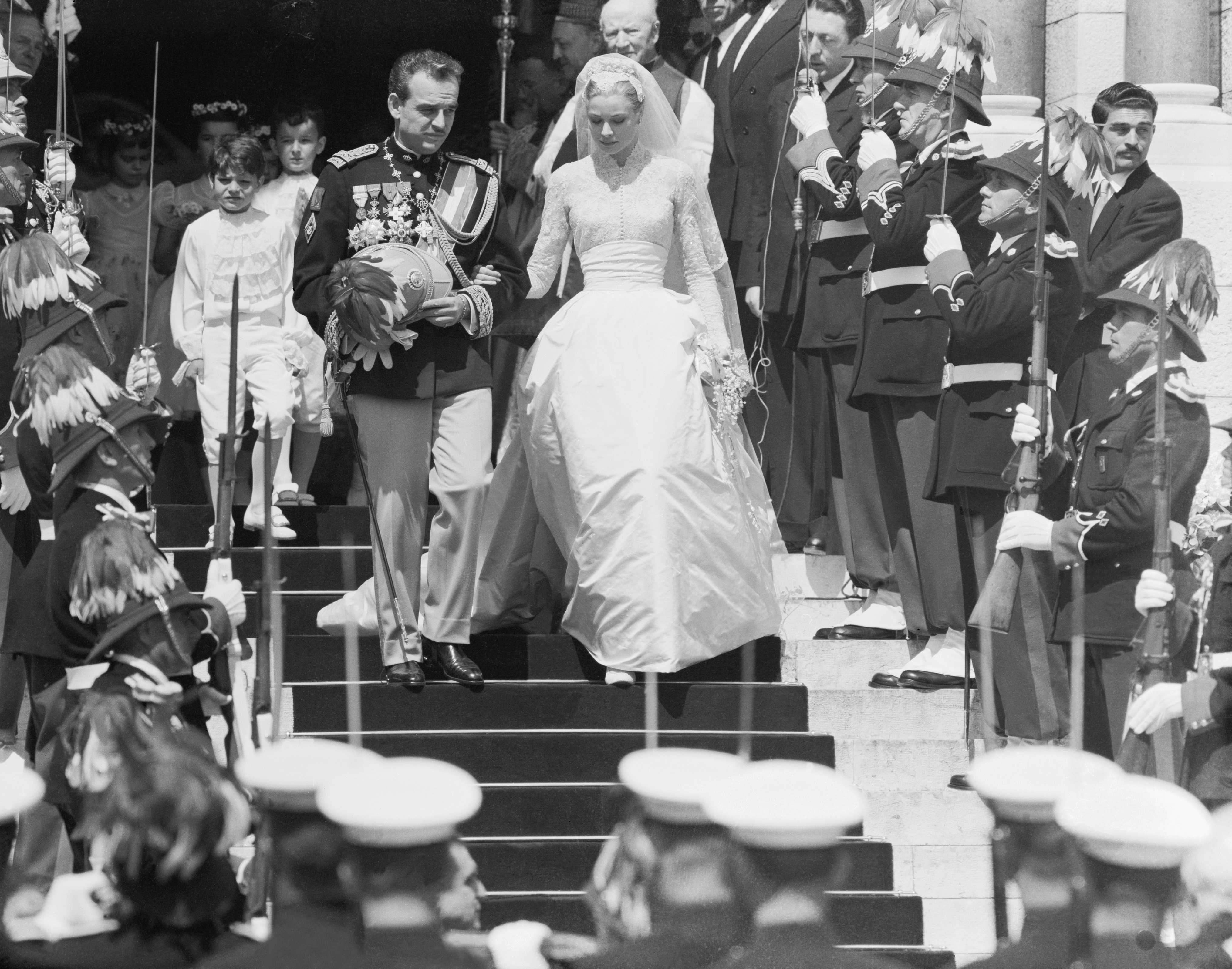 Prince Rainier and Grace Kelly walk down the steps of a church just after getting married