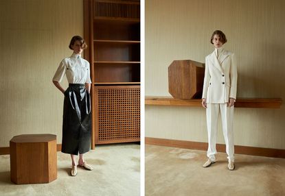Model wears black patent skirt with white shirt and white suit with high collar shirt underneath