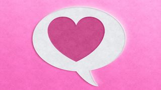 Speech bubble with pink heart shape on pink background.