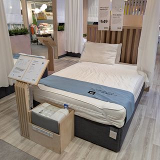 A mattress showroom with a wooden floor and multiple mattress on bed frames