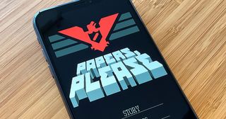 Photo of Papers, Please on an iPhone screen.