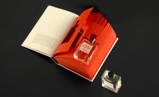 A bottle of Paper Passion perfume set into the pages of an open book