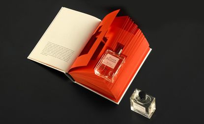 A bottle of Paper Passion perfume set into the pages of an open book