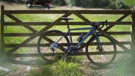 Boardman gravel bike leaning against a gate