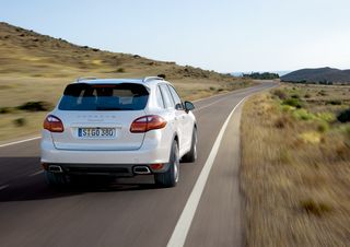 Action shot of the rear view of a white Porsche Cayenne S Hybrid
