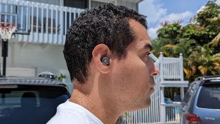 Hero image for best cheap headphones showing reviewer wearing Edifier W240TN