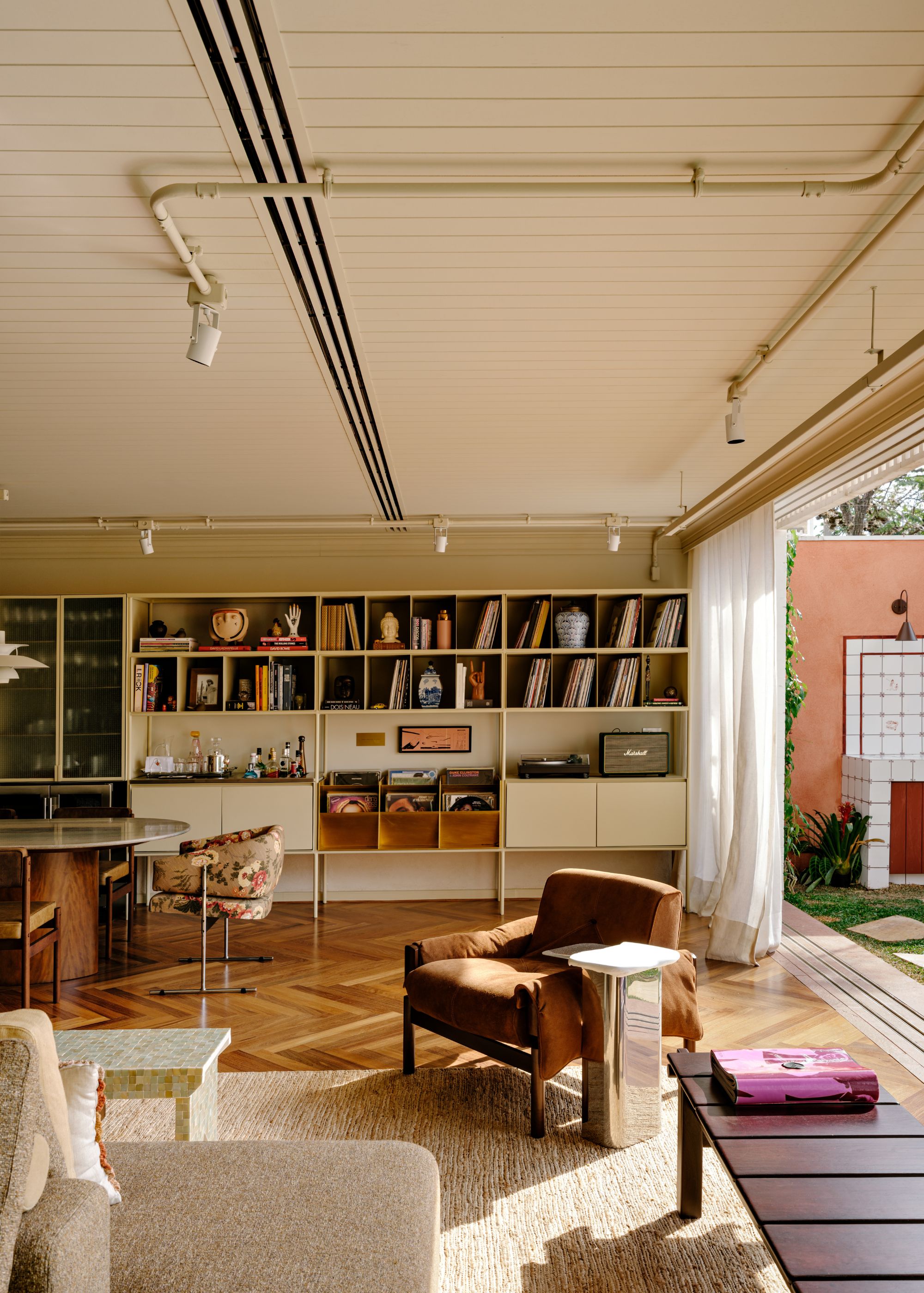 A living room with low furniture, natural fibre carpet and built-in storage
