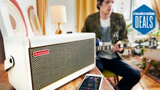 Man plays guitar with a Positive Grid Spark Pearl amp and smartphone in the foreground