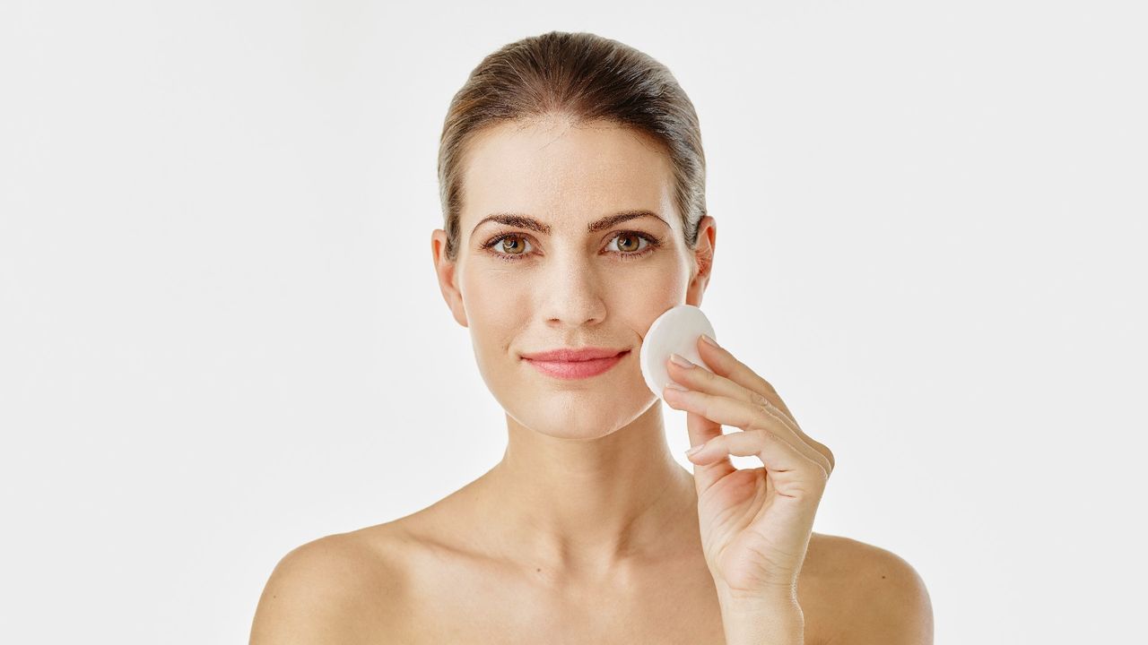 woman using toner on a cotton pad