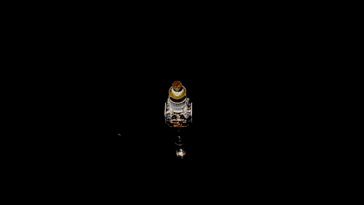 a lone spacecraft hangs in the solid black of space.