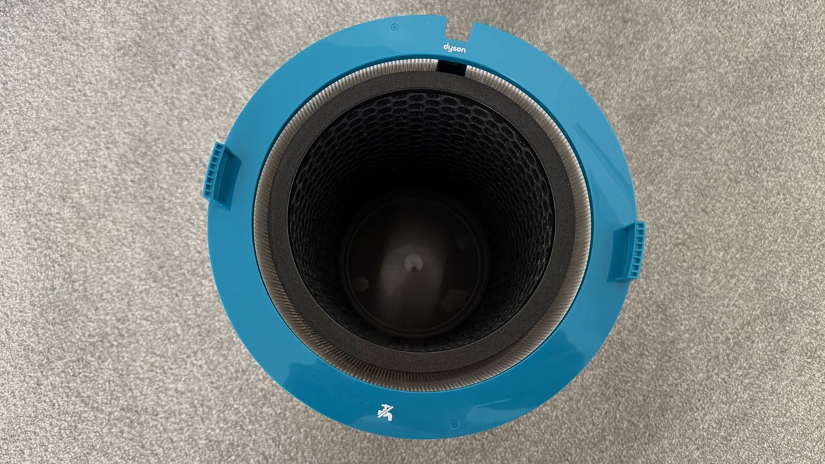 Top-down view of the Dyson HushJet cylindrical filter housing with blue outer casing and internal filtration chamber visible