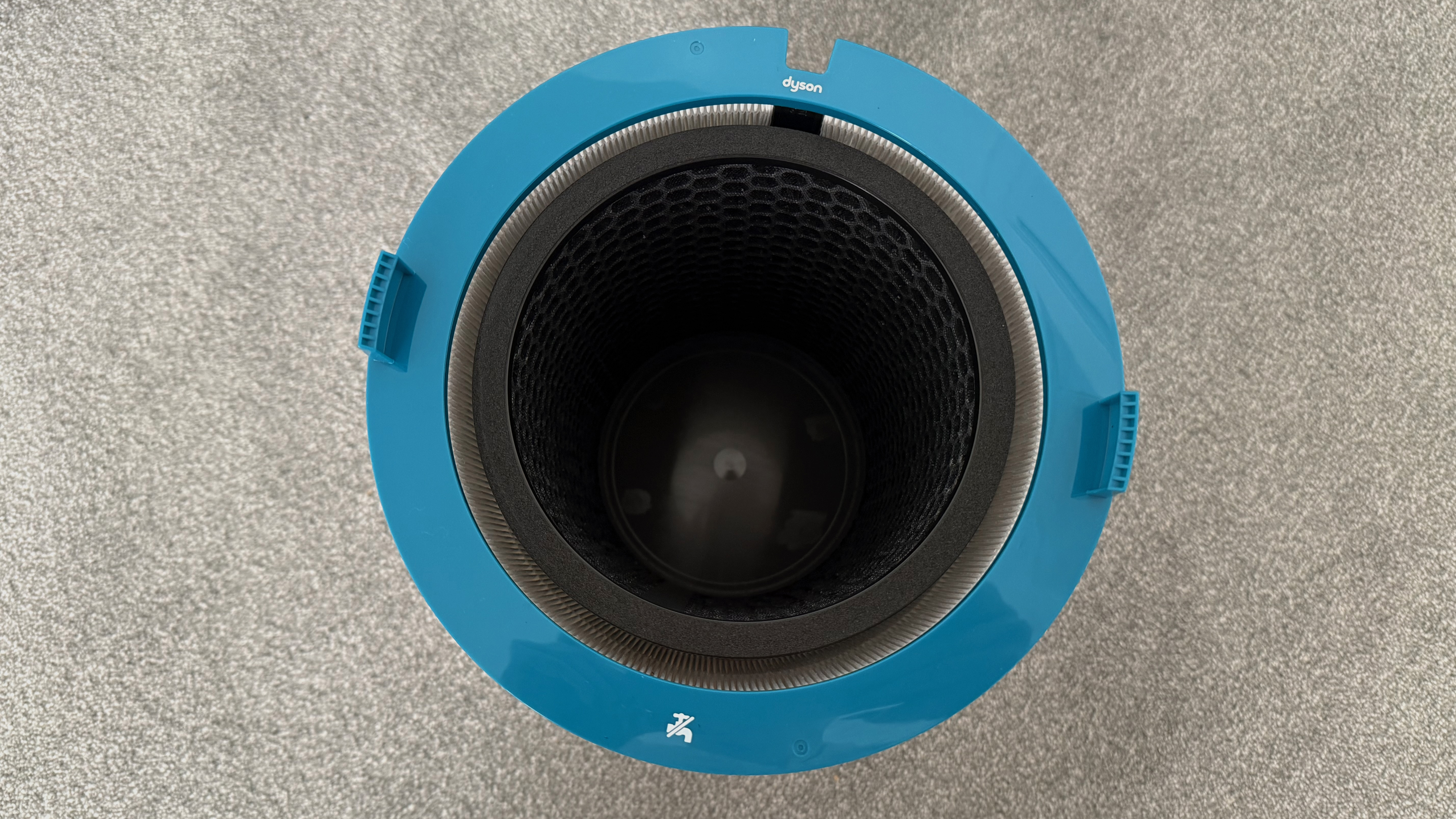 Top-down view of the Dyson HushJet cylindrical filter housing with blue outer casing and internal filtration chamber visible