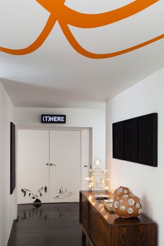 Apartment entryway with neon art sign and sideboard