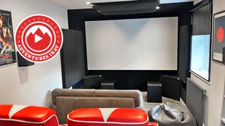 A photo of a dedicated home cinema room with red chairs and a Blade Runner poster on the wall