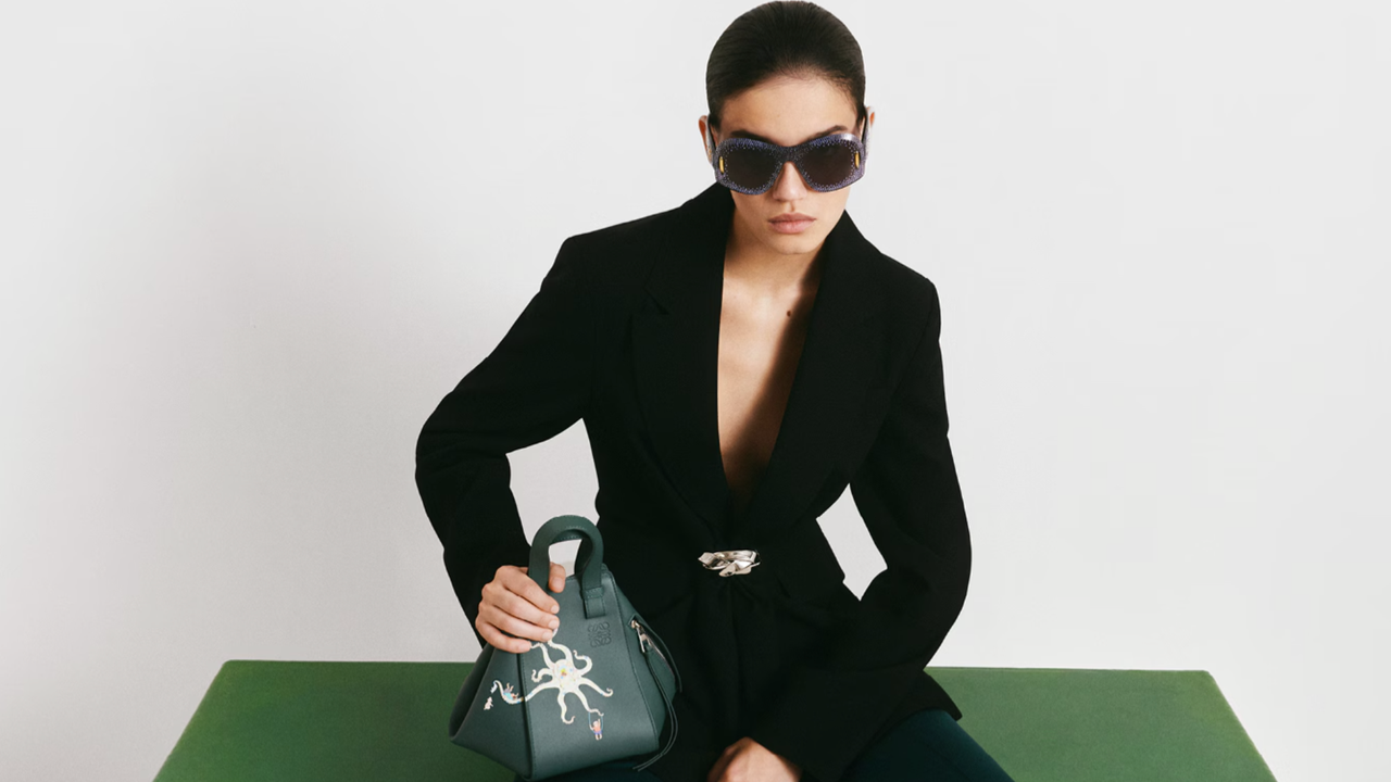 Mytheresa campaign imagery woman wearing black suit and sunglasses