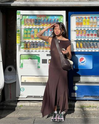 @vivianyrl styles her asymmetric maxi dress with colourful Salomon trainers.