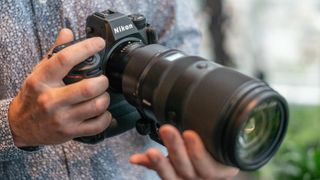 Close up photo of hands holding Nikon Z9 with Nikon Z 100-400mm f/4.5-5.6 VR S lens