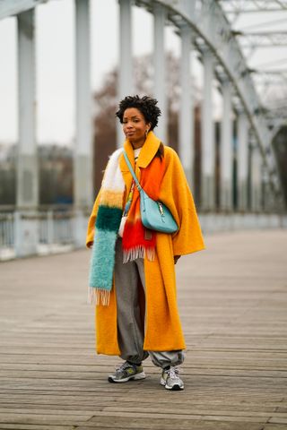 woman wearing coat, shirt, baggy pants, and sneakers