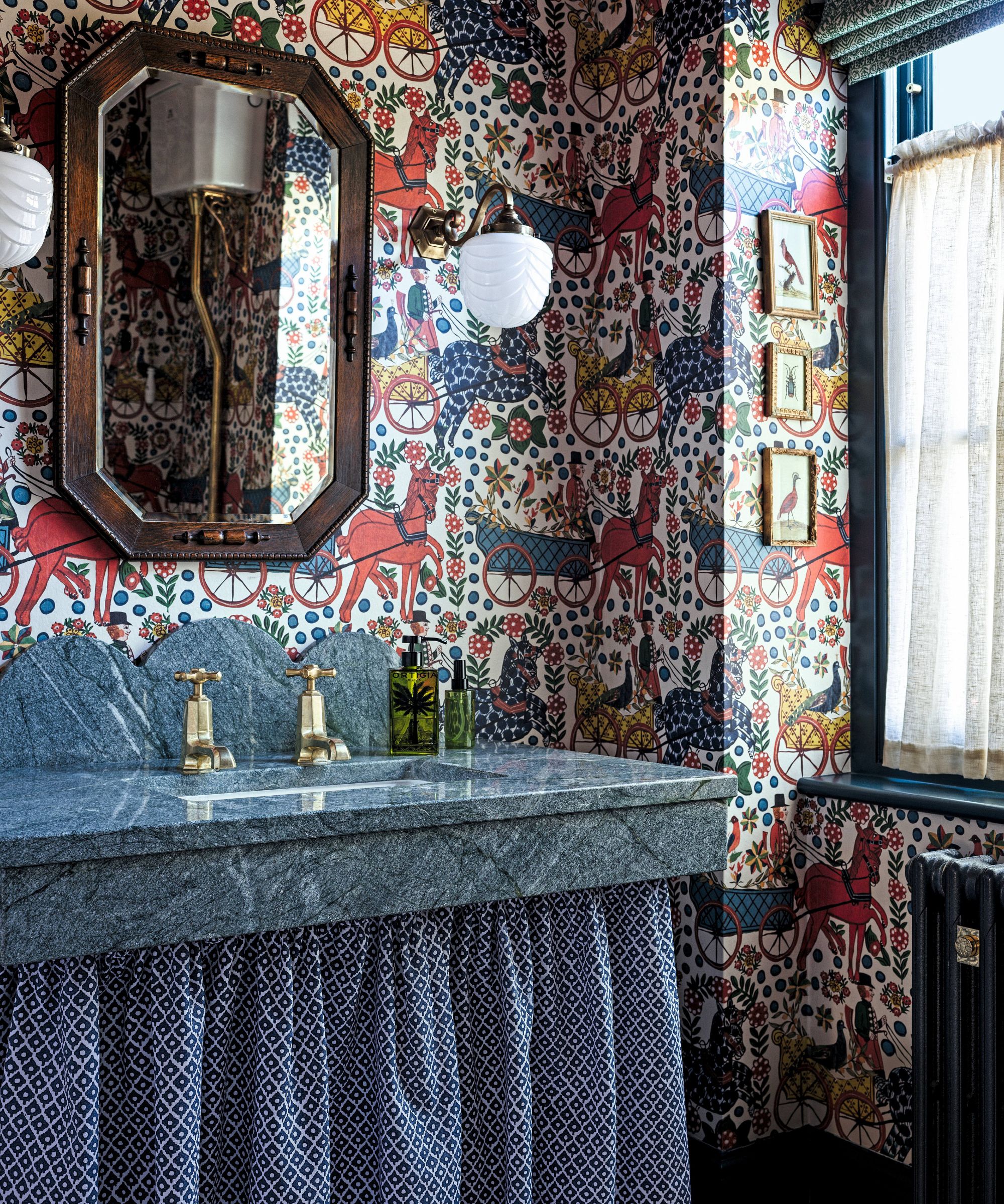 a unique powder room with statement wallpaper and a blue marble scalloped vanity with a curtain bottom