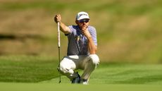 John Catlin crouches down with putter in hand at the 2024 International Series England