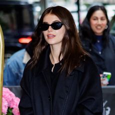Kaia Gerber wearing head-to-toe black and Nike sneakers while at the Carlyle Hotel in New York City May 2024