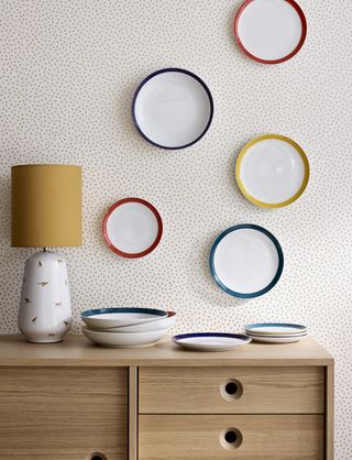 gold spot wallpaper with plates and sideboard in front