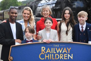 Jenny Agutter in red, at Oakworth station and the premiere of The Railway Children Return with her co-stars.