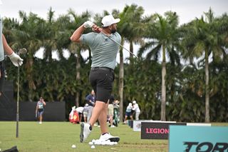 Jon Rahm strikes an iron on the range at LIV Golf Miami