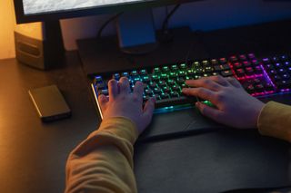 Hands on a multi colored gaming keyboard