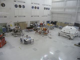 Pieces of NASA's Mars Science Laboratory mission at the Jet Propulsion Laboratory in May 2011. From left: the Curiosity rover (along rear wall; its tires are on a table to the rover's right), the entry-descent-landing stage, the cruise stage and the backshell.