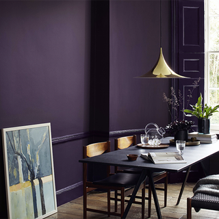 purple wall with table and chair and wooden flooring