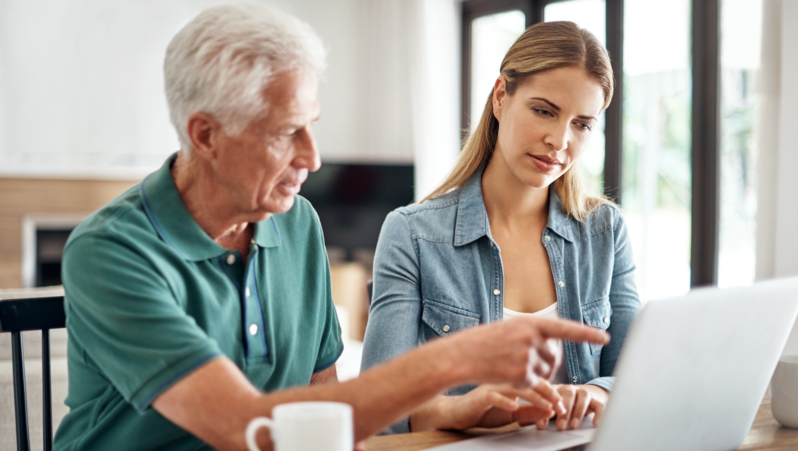 A senior man goes over his finances with the help of his daughter.