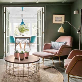 Green living room with pink armchairs