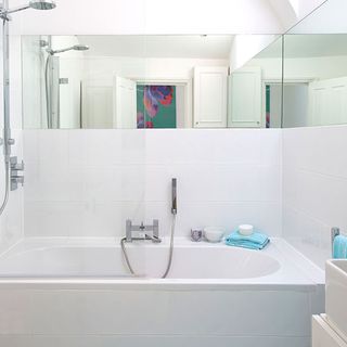 white modern bathroom with white bath tub and mirror on wall