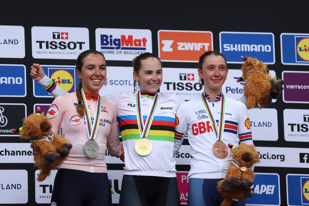 Silver medalist Shirin Van Anrooij, gold medalist Blanka Vas Kata, and bronze medalist Anna Shackley celebrate on the podium during the U23 women&#039;s medal ceremony after the combined U23-elite women&#039;s road race at the World Championships in Glasgow 2023